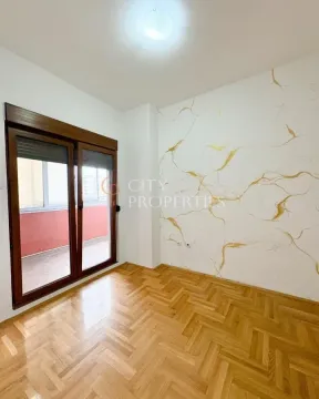 Empty room with parquet flooring and balcony access. - image 9