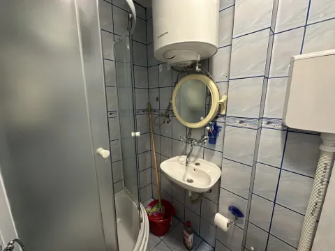 Smaller bathroom with a shower cabin, washbasin, and water heater. - image 3