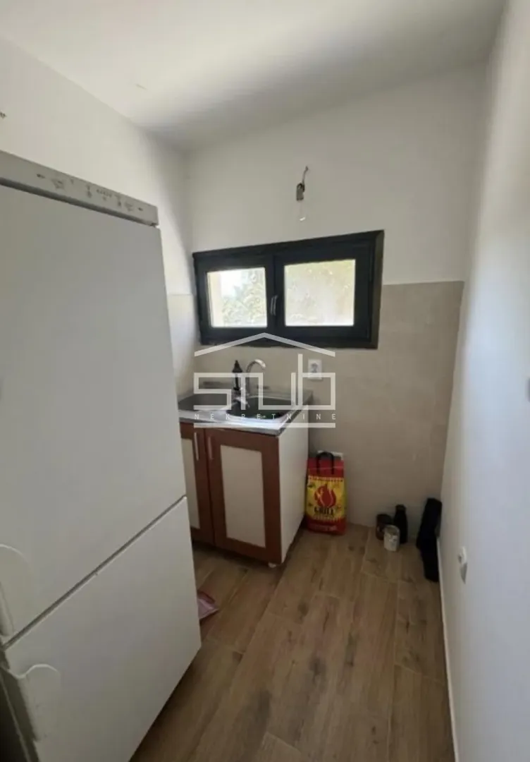 Manja kuhinja sa frižiderom i sudoperom.
