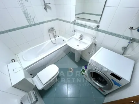 Kupatilo opremljeno kadom, umivaonikom, toaletom i veš mašinom. - image 9