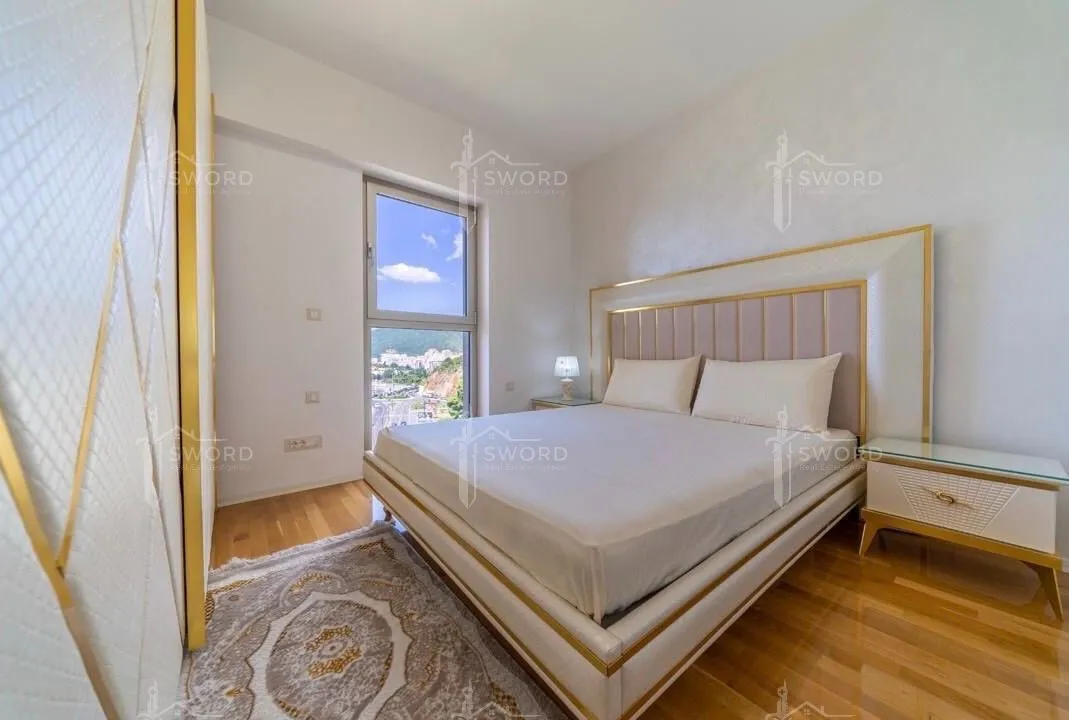 Bright bedroom with a double bed, wardrobe, and a window view.