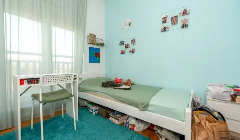 Children's bedroom with a bed, desk, and blue walls. - image 9