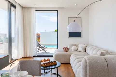 Modern living room with a comfortable sofa and a view of the terrace with a swimming pool. - image 10
