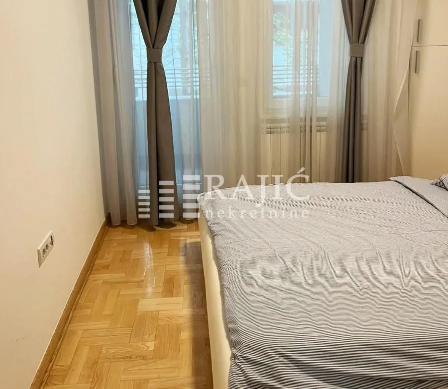 Bedroom with a double bed and a window with curtains.