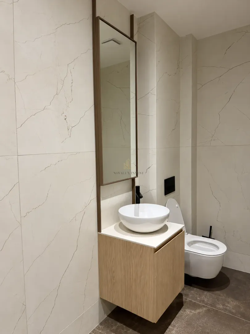 Modern bathroom with a vanity washbasin and wall-hung toilet.