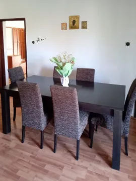 Dining area with a dark wooden table and six upholstered chairs. - image 12