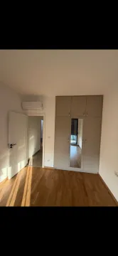 Bright bedroom with a fitted wardrobe, wooden flooring, and an air conditioner. - image 5