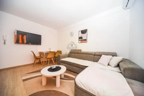 Living room with a sectional sofa, coffee table, and dining area. - image 2