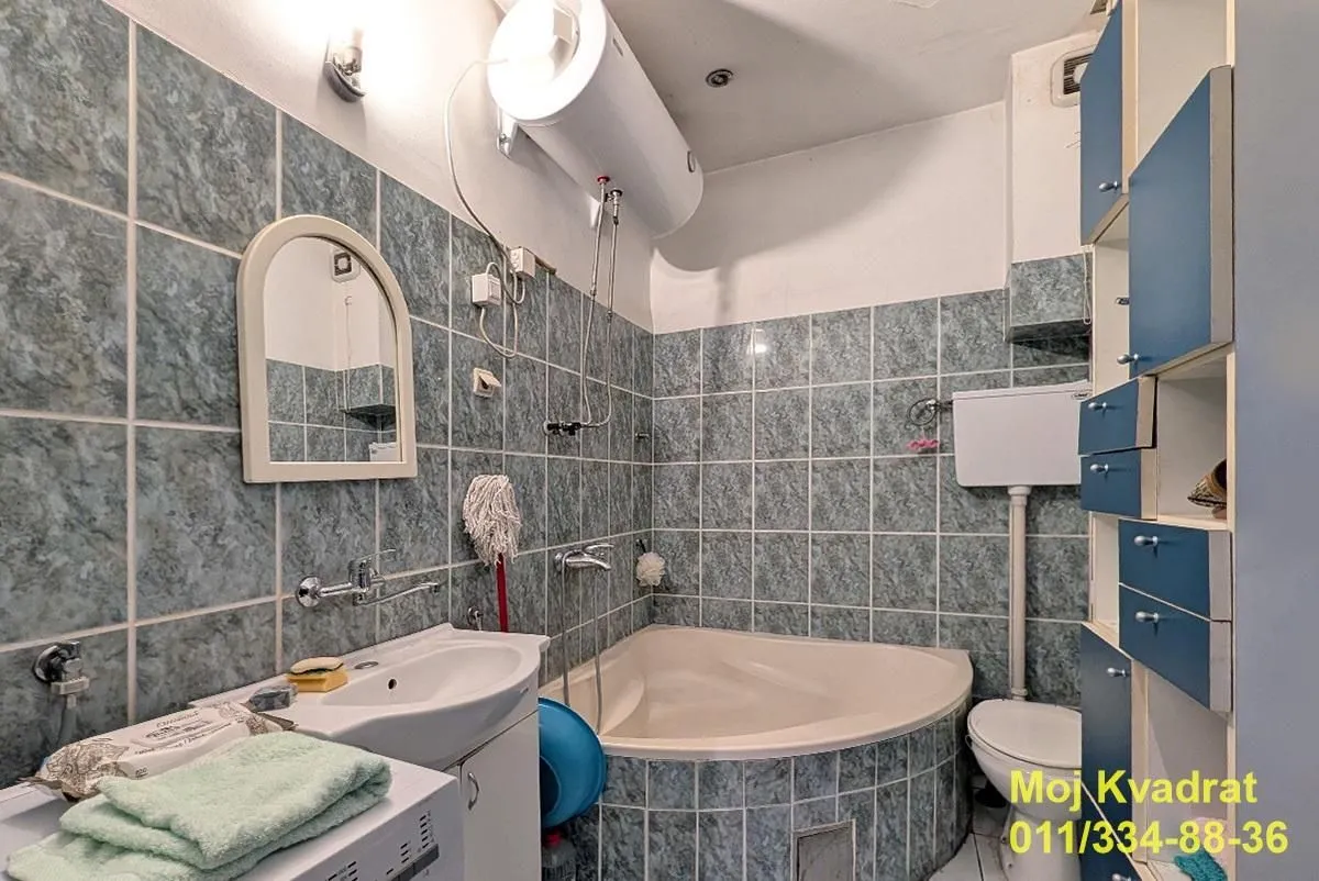 Kupatilo obloženo pločicama sa kadom, umivaonikom i wc šoljom.