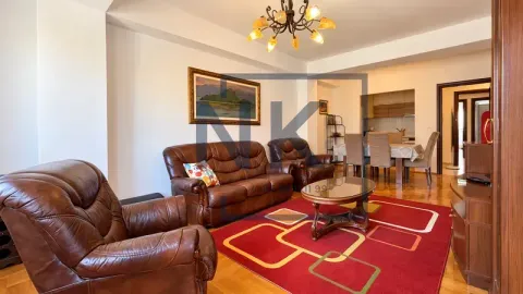 Spacious living room with leather sofas, dining area in the background, and parquet flooring. - image 3