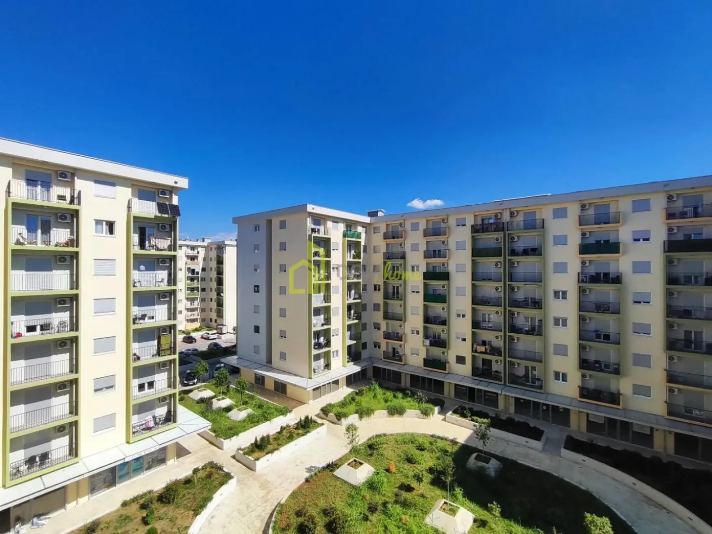 View of the residential building facades and landscaped inner courtyard with greenery.