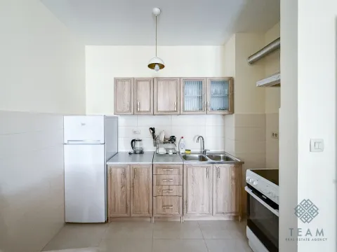 Manja kuhinja sa drvenim elementima, frižiderom i šporetom. - image 4
