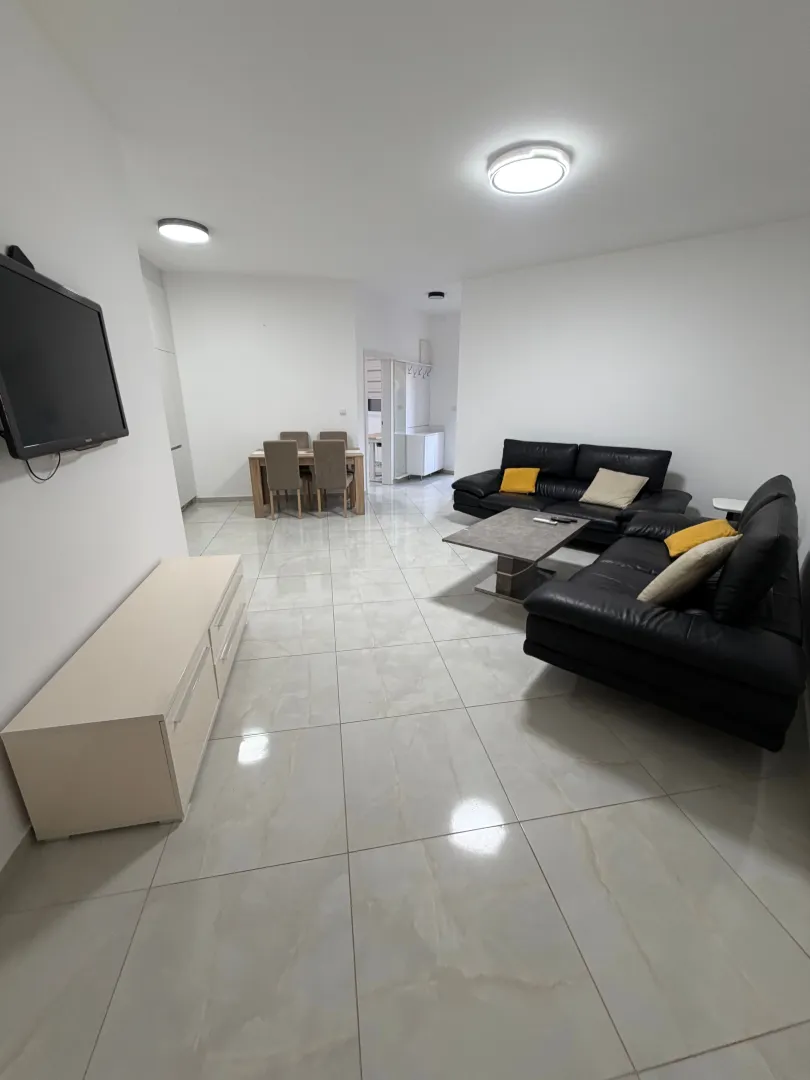 Spacious living room with sofa set and dining area.