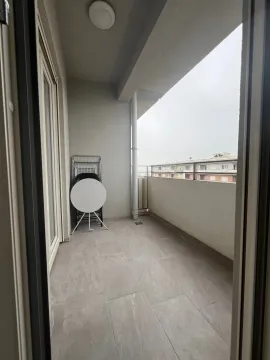Covered balcony with ceramic tiles and a view of surrounding buildings. - image 9