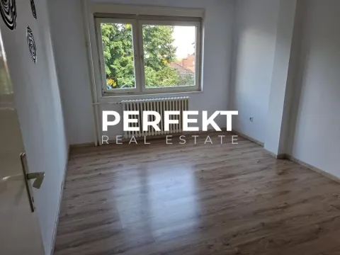 Prazna soba sa laminatom i prozorom koji gleda na dvorište. - image 17