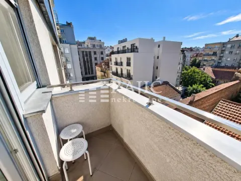Small balcony with seating furniture and city view. - image 8
