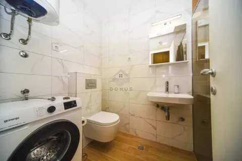 Modernly equipped bathroom with a washing machine, sink, toilet, and shower cabin. - image 7