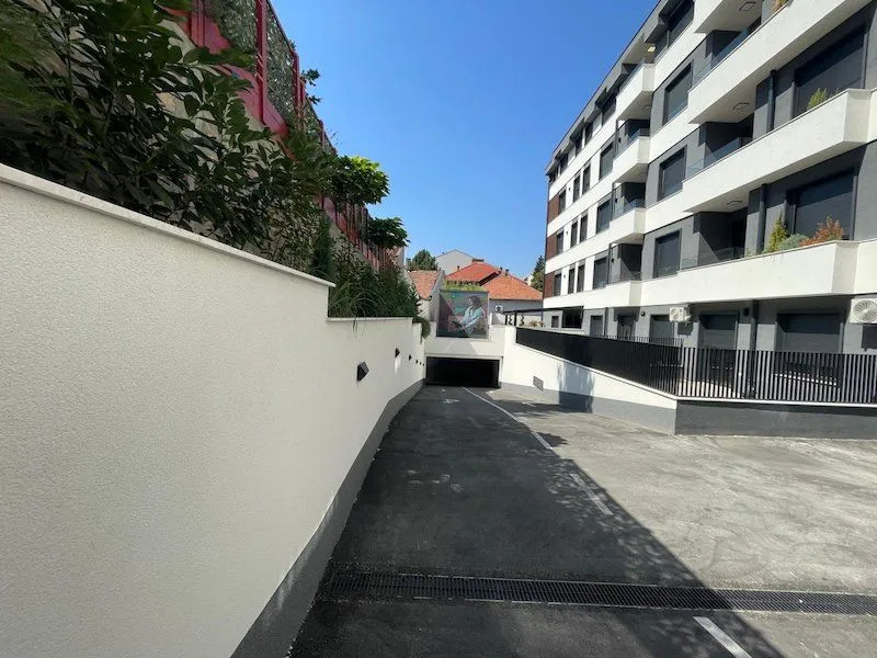 Driveway to the underground garage of a modern residential building from the outside.