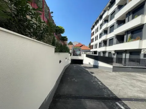 Driveway to the underground garage of a modern residential building from the outside. - image 19