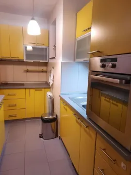 Kitchen with yellow cabinets and a built-in oven. - image 3