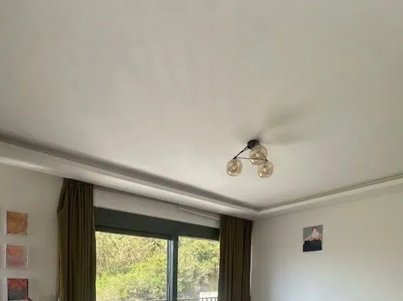Pogled na plafon i dio dnevne sobe sa rasvjetom.