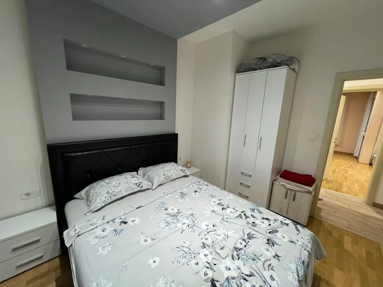Furnished bedroom with a double bed, wardrobe, and white nightstands.