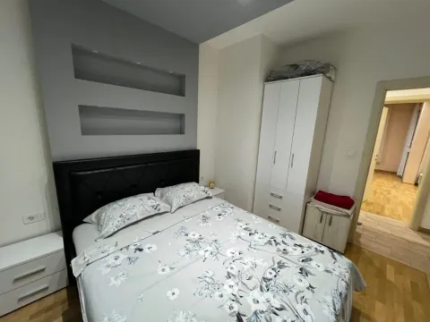 Furnished bedroom with a double bed, wardrobe, and white nightstands. - image 4