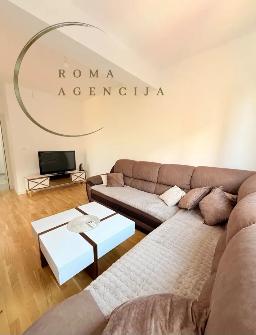 Living room with a sectional sofa, coffee table and TV.