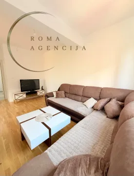 Living room with a sectional sofa, coffee table and TV. - image 3