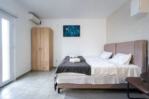 Svjetla i uredna spavaća soba sa bračnim krevetom i drvenim ormarom. - image 3