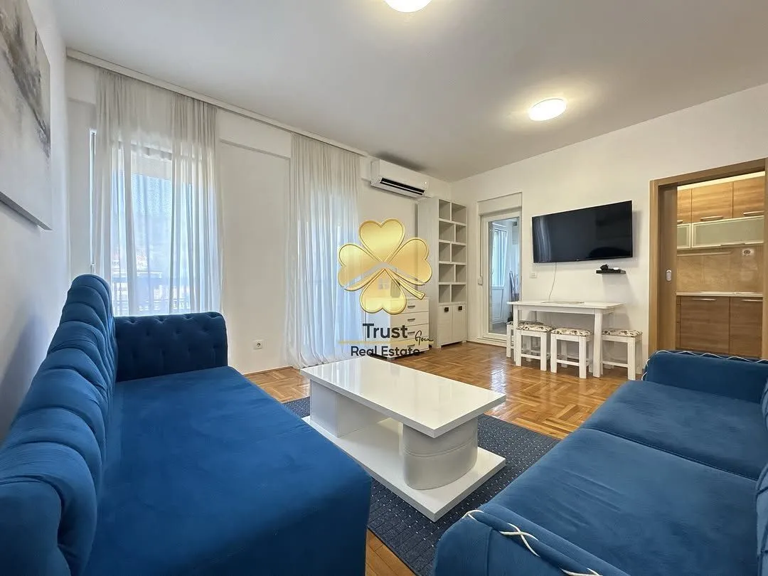 Spacious living room with blue sofas and a white coffee table.