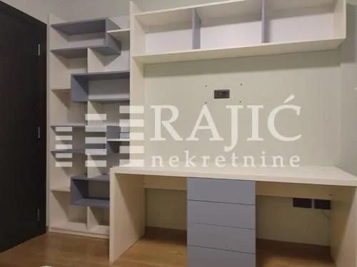 Children's room with a desk and white shelves.