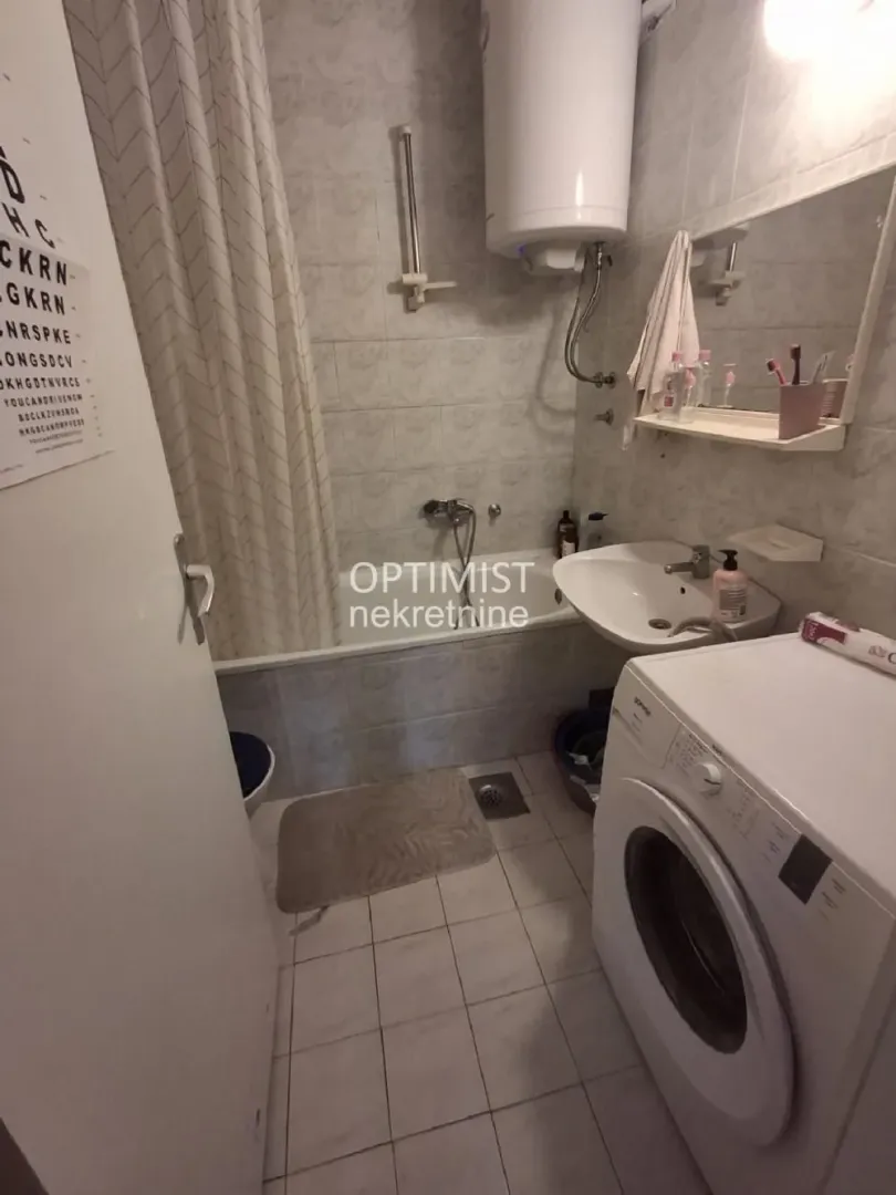 Kupatilo opremljeno kadom, umivaonikom, veš mašinom i bojlerom.