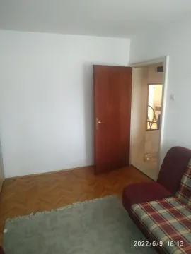 Jednostavna soba sa parketom i kaučem pored otvorenih vrata. - image 3
