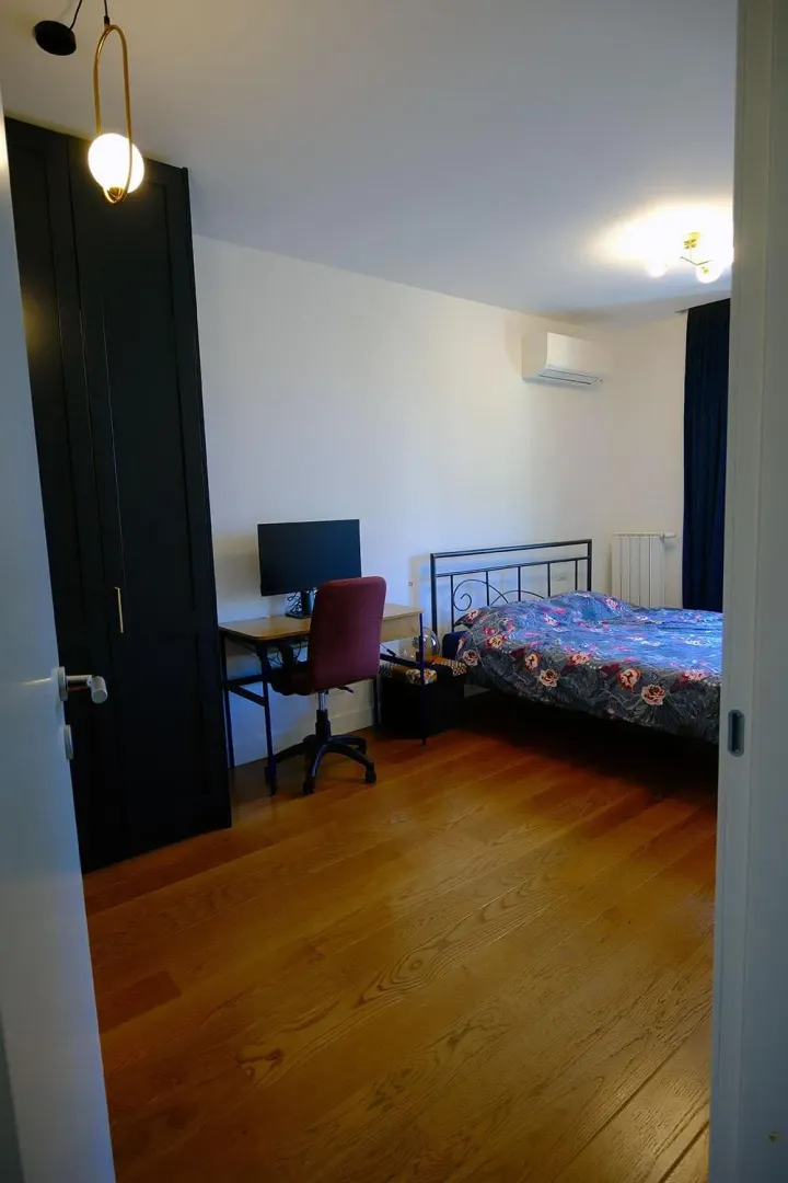 Bedroom with a double bed, a desk, and a dark wardrobe.
