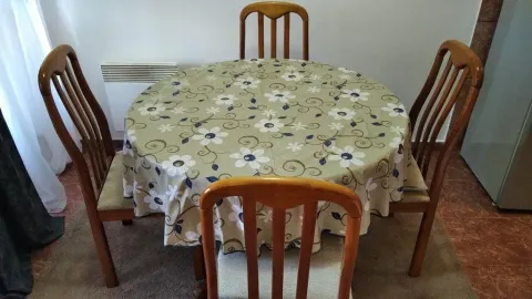 Trpezarijski sto sa četiri drvene stolice prekriven stolnjakom. - image 18