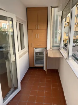 Enclosed balcony with wooden cabinetry and a refrigerator. - image 4