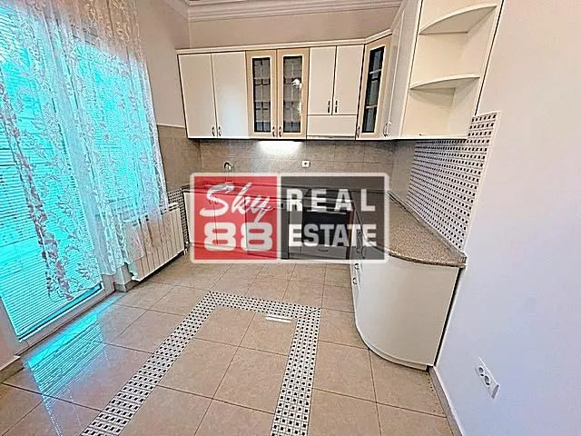 Kitchen with white cabinetry and ceramic floor tiles.