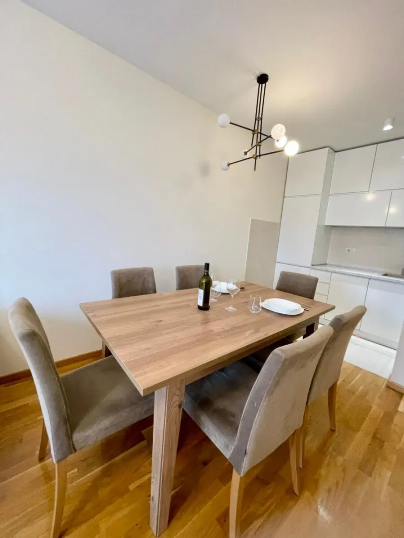 Dining table with chairs as part of the living area with a kitchen.