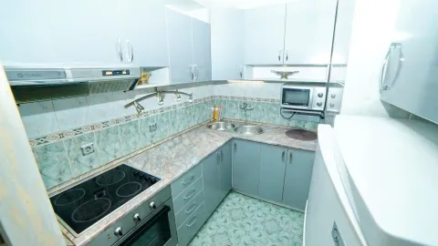 Bright kitchen with built-in appliances and grey-blue cabinets. - image 12