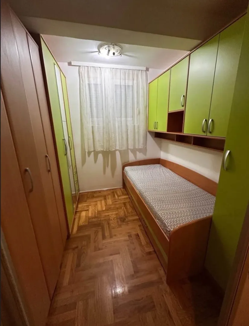 Dječja soba sa krevetom i ugradnim ormarima.