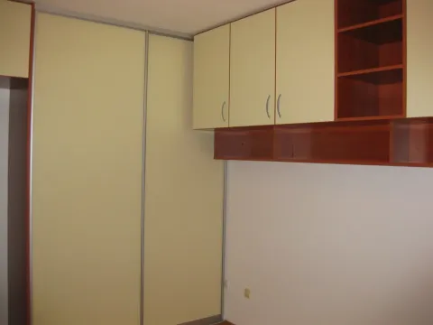Built-in wardrobe with sliding doors and wall cabinets in the room. - image 7