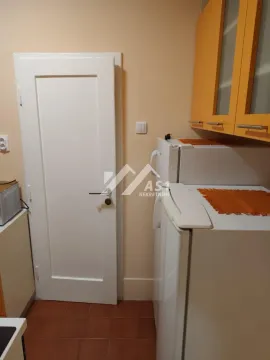 Deo kuhinje sa frižiderom, belim vratima i žutim zidnim elementima. - image 8