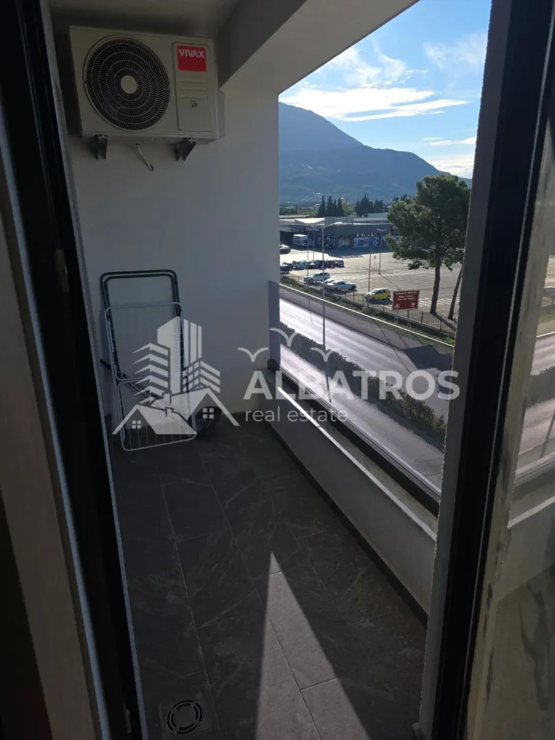 Small balcony with tiles and a view of the surroundings.