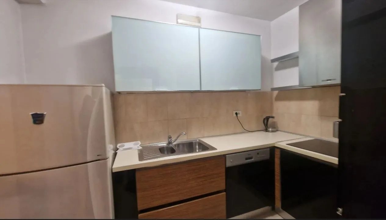 Simple kitchen with wood-tone cabinets and a refrigerator.