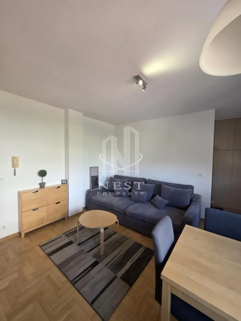 Living room with a sofa, coffee table, and dining table.