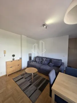 Living room with a sofa, coffee table, and dining table. - image 2