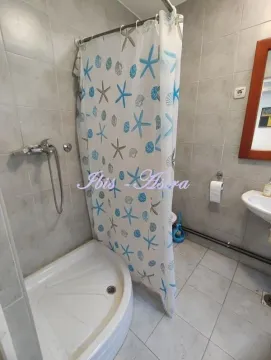 Bathroom with a shower cabin, washbasin, and tiled walls. - image 12