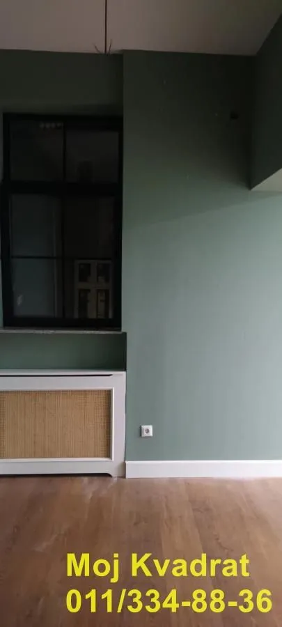 Empty room with green walls, wooden floor and a window.