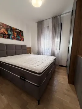 Moderna spavaća soba sa bračnim krevetom, drvenim podom i ormarom. - image 9